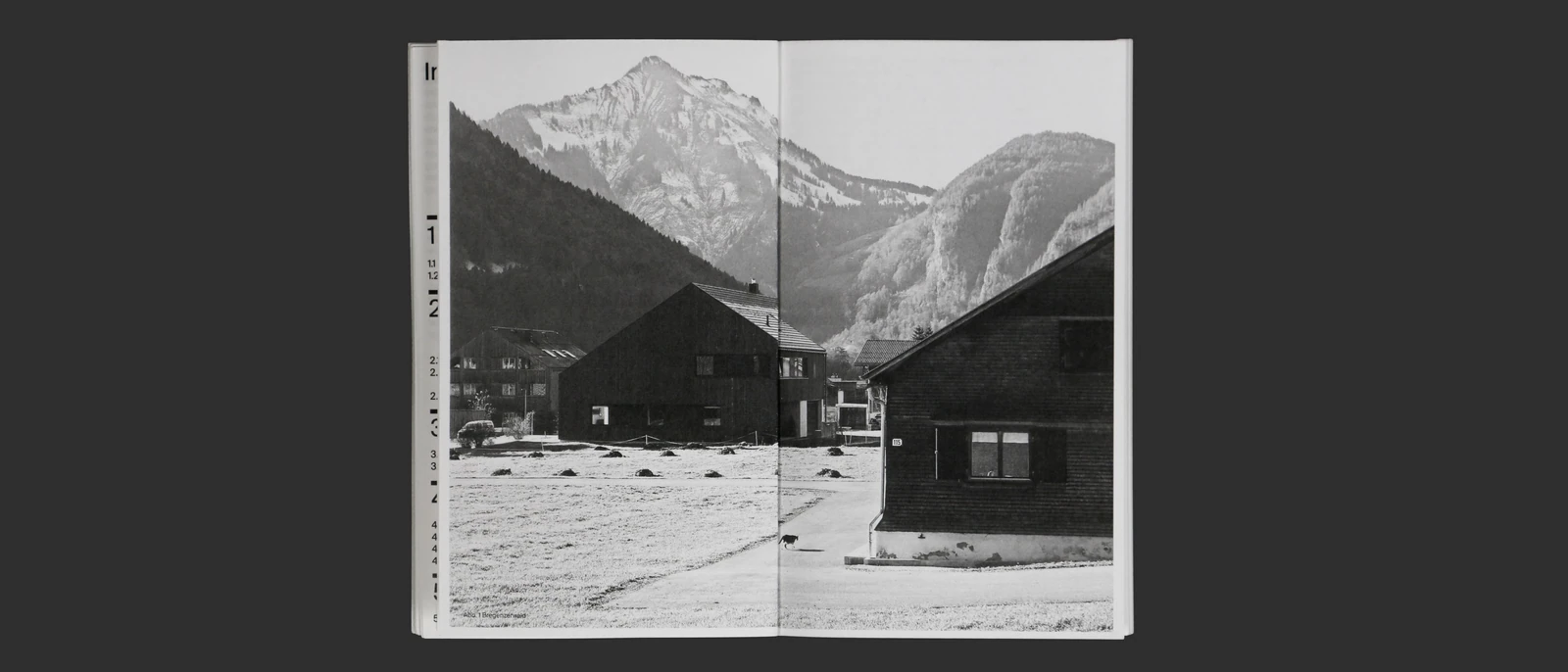 Open book spread with a black-and-white photograph of an Alpine village.
